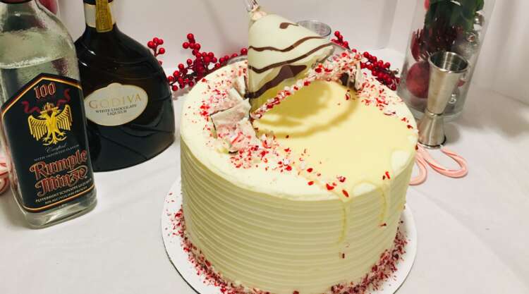 White Chocolate Grasshopper Cake - topped with a white chocolate drip, crushed candy canes, and a martini glass