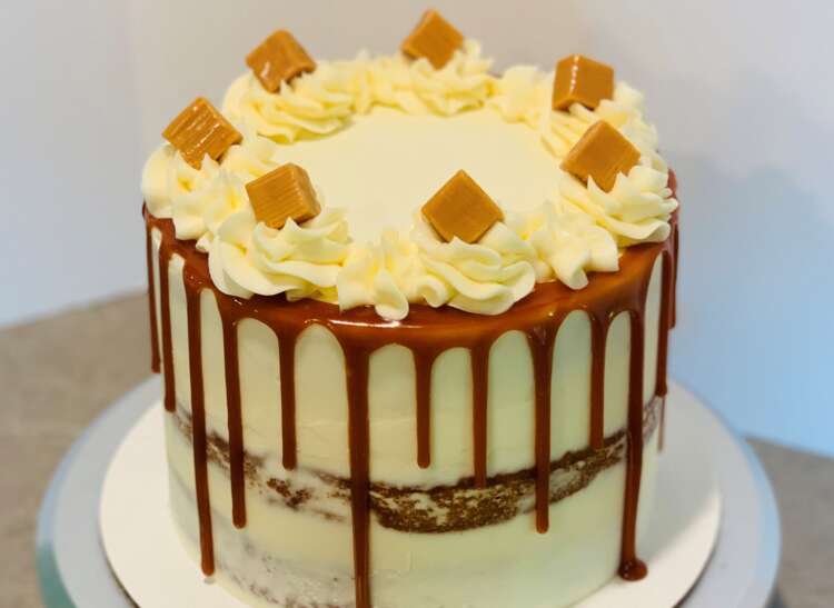 Banana Caramel Cake (semi-naked cake with caramel drip and caramel squares and frosting swirls on top)