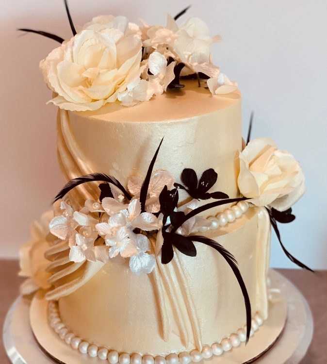 Draped Wedding Cake (gold and ivory, decorated with fondant drapes and black and ivory flowers and feathers)