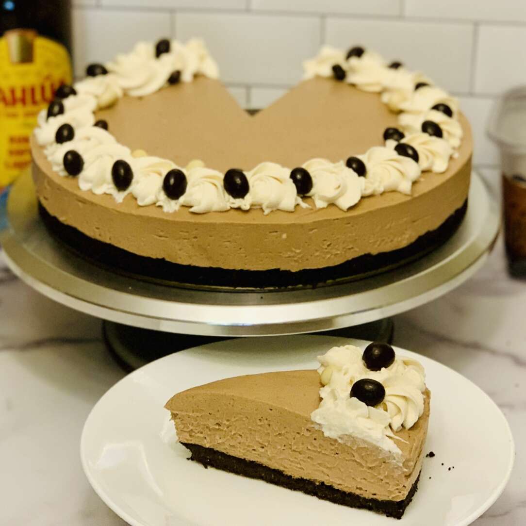 No-bake espresso martini cheesecake; slice cut from cheesecake in foreground. Remainder of cheesecake in the background.