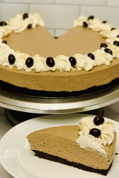 Espresso Martini Cheesecake No-bake espresso martini cheesecake; slice cut from cheesecake in foreground. Remainder of cheesecake in the background.